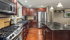 Una cocina moderna con armarios de madera, electrodomésticos de acero inoxidable y una isla grande.
