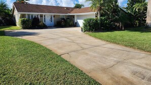 A single-story house with a front driveway leading to a garage. - Intercostal channel house with boat dock and ping-pong table  (South Daytona)