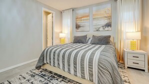 A bedroom with a bed, bedside tables, and artwork on the wall. - Central Casa Grande Home in Quiet Neighborhood (Casa Grande)