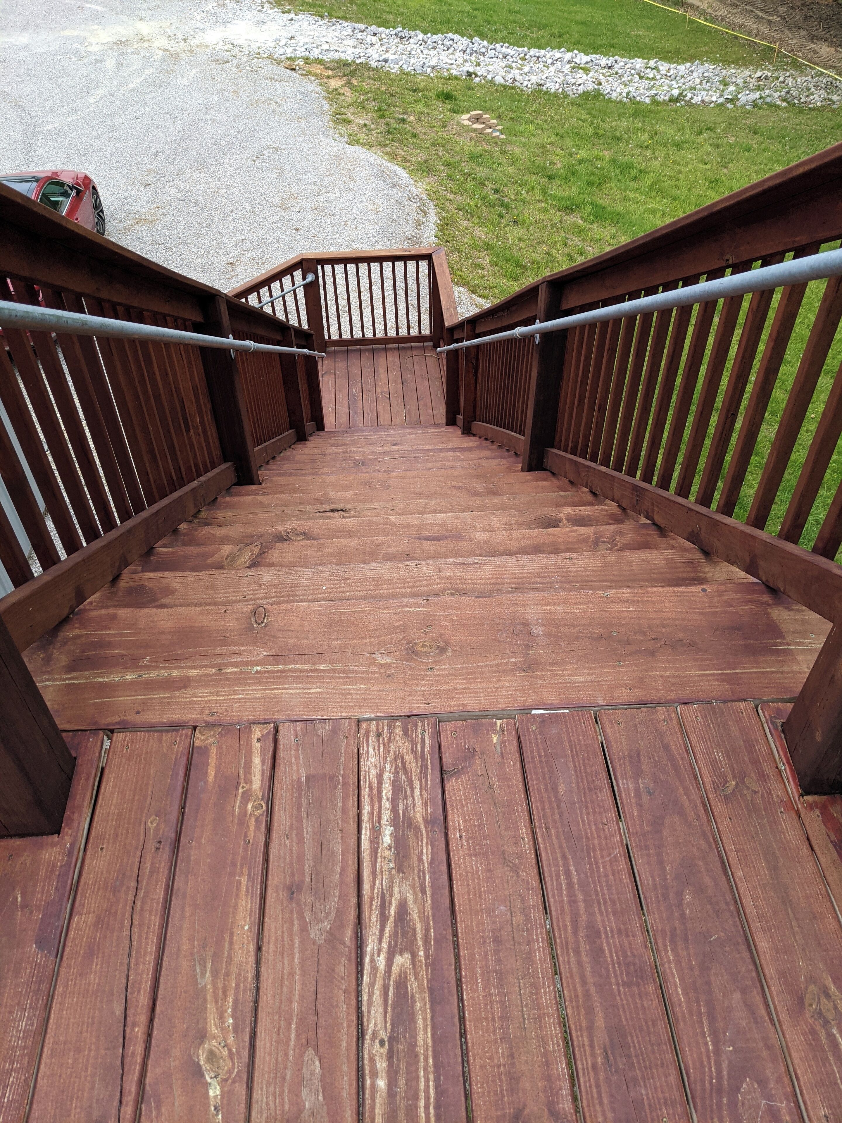 A wooden staircase leading to a higher level, surrounded by a metal railing.