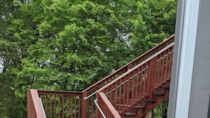 A wooden staircase with metal railings leading to an upper level. - Cozy 2-bedroom corporate apartment minutes from Lake Cumberland Kentucky.   (Albany)