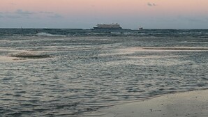 A beach with a large ship in the distance, calm sea, and a clear sky. - Oceanfront Penthouse in Puerto Plata (Puerto Plata)