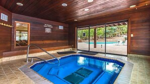 Una piscina interior con revestimiento de madera, una puerta de cristal que da al exterior, y un letrero que indica que no se permiten menores de 6 años.