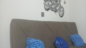 Een bruine bank met drie blauwe, gestructureerde kussens.