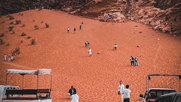 Paisaje desértico con formaciones rocosas y algunas personas caminando.