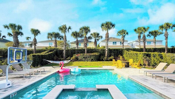 Une piscine avec un jacuzzi, des chaises longues et un flotteur en forme de flamant rose.