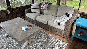 A cozy room with a wicker sofa, a wooden coffee table, and a blue side table. - Perfect Cabin on Pokegama Lake (Grand Rapids)
