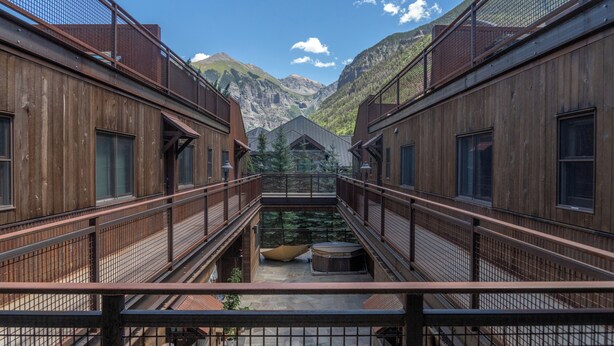 A corridor with wooden walls and metal railings, leading to a mountain view. - Amazing Top Floor Ghostrider (Telluride)
