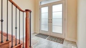 Una scala con corrimano in legno e una porta con pannelli di vetro satinato.