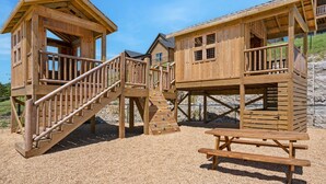 Wooden play structures with a picnic table. - New Log Cabin with Ozark Views, Free Daily Local Attraction Tickets & Community Amenities (Branson)