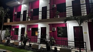 A multi-story building with a modern design, featuring a combination of white and maroon colors, multiple balconies, and air conditioning units. - Room 805 @ Pennington Inn, Guimaras (Western Visayas)