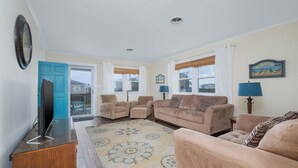 A living room with a TV, sofas, and a patterned rug. - 4770 - I'm Free - Semi-Oceanfront Oasis w/ Pool & Hot Tub (Kitty Hawk)