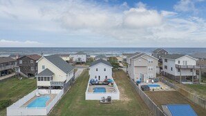 A residential area with houses, a swimming pool, and a view of the ocean. - 4770 - I'm Free - Semi-Oceanfront Oasis w/ Pool & Hot Tub (Kitty Hawk)