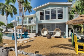 A two-story house with a pool, outdoor seating, and tropical landscaping. - Rest A Shore Waterfront Home, Brand New Private Pool (Marathon)