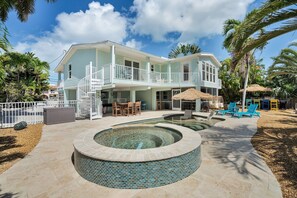 A two-story building with a pool, outdoor seating, and a covered patio area. - Rest A Shore Waterfront Home, Brand New Private Pool (Marathon)