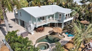 A two-story house with a balcony, a swimming pool, and a hot tub.