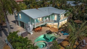 A two-story building with a pool area, including a hot tub and a children's play area.