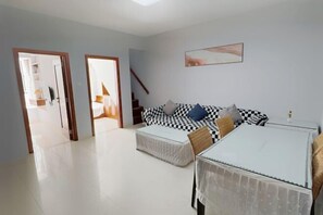 A room with a checkered sofa, a small table, and a staircase. - Sanya Seaside Breeze Homestay (Sanya)
