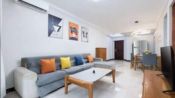 A living room with a sofa, coffee table, and a TV.