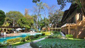 A poolside area with a clear view of a swimming pool, lounge chairs, and a well-maintained garden. - Samed Hideaway Resort (Koh Samet)