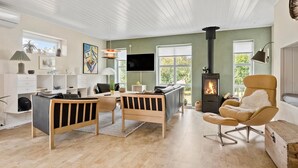 Una sala de estar moderna con chimenea, un comedor y una zona de estar acogedora.