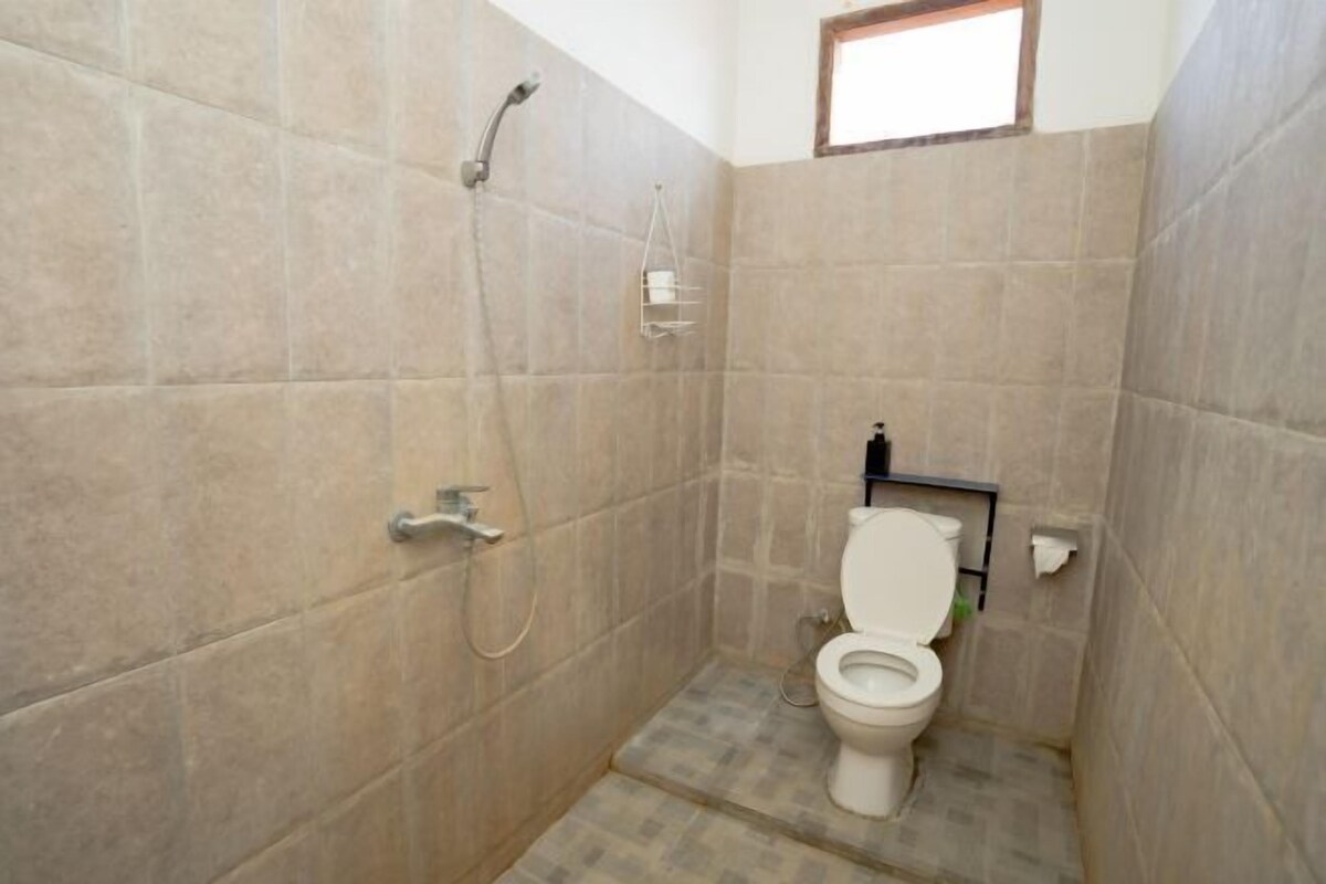 A small bathroom with a toilet, a shower, and a towel rack.