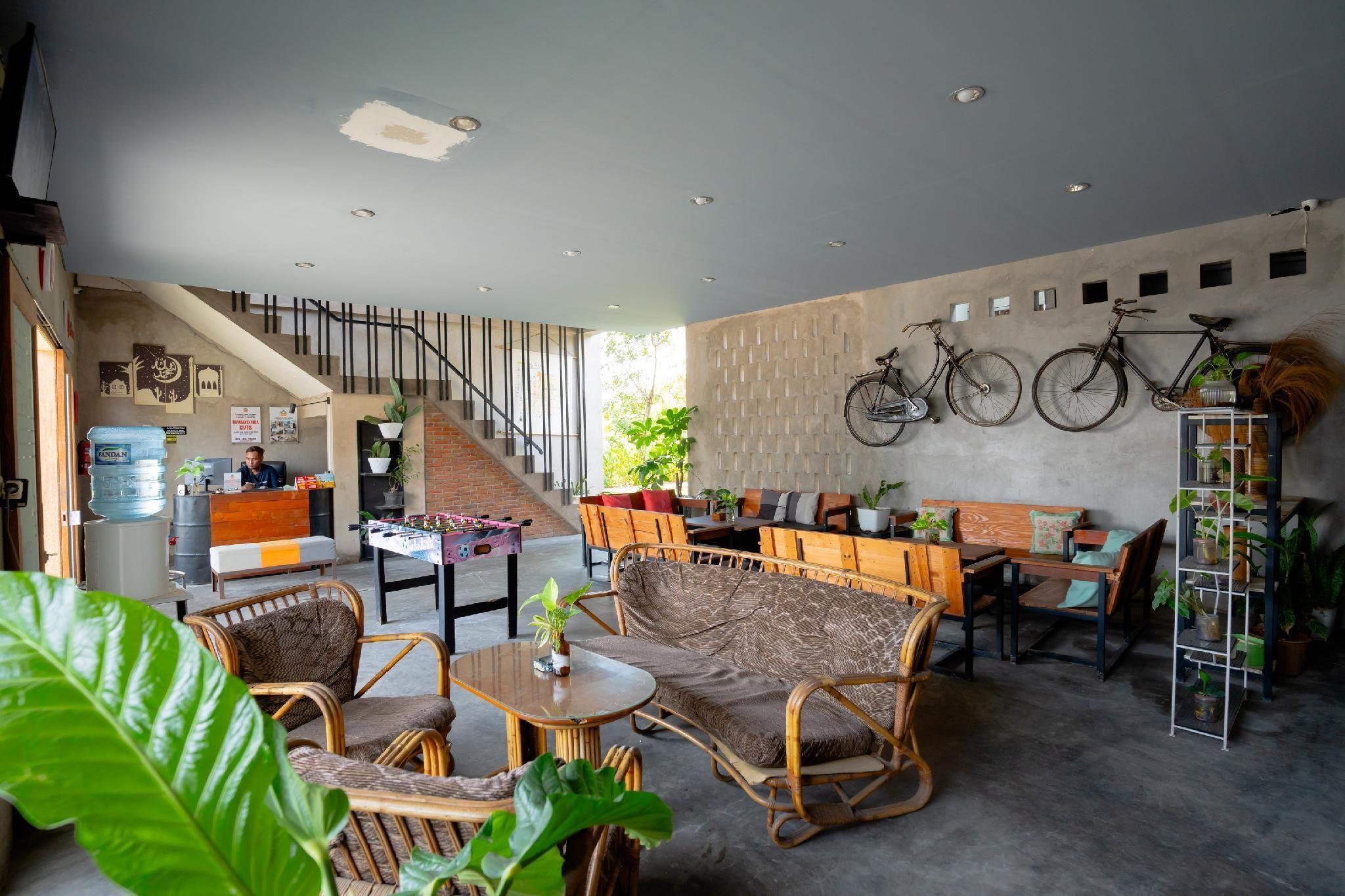Um hall amplo com escada, área de estar e bicicletas fixadas na parede.