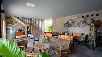 Um hall amplo com escada, área de estar e bicicletas fixadas na parede.