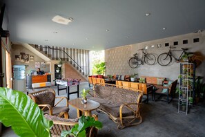 A spacious lobby with a staircase, seating area, and bicycles mounted on the wall. - Formerly Reddoorz Syariah Lombok Epicentrum Mall (Mataram)