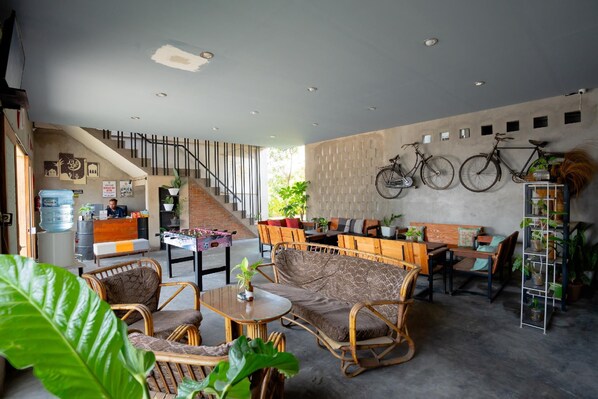 Eine großzügige Lobby mit Treppe, Sitzgelegenheiten und Fahrrädern, die an der Wand befestigt sind.