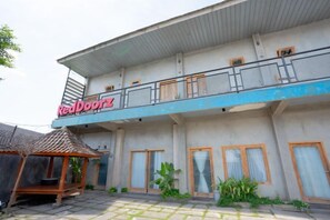 Un immeuble de deux étages doté d’un balcon et d’une enseigne sur laquelle on peut lire « Red Doorz ».