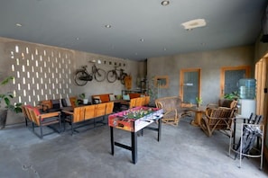 Une pièce comprenant une table à manger, des chaises, un canapé et des vélos accrochés au mur.
