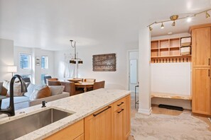 A modern kitchen with a marble countertop, wooden cabinets, and a built-in oven. - Beaver Creek Residences 2 Bedroom Luxury Vacation Rental (Avon)