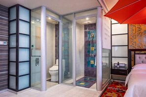 A modern hotel room with a glass-enclosed shower, a toilet, and a bed with a red umbrella. - AutobotsOutbots Hotel (Aquarium Station) (Zhengzhou)