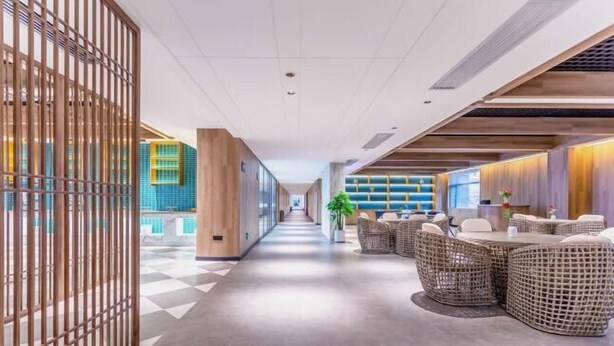 A modern hotel lobby with a checkered floor, a reception desk, and wicker furniture. - AutobotsOutbots Hotel (Aquarium Station) (Zhengzhou)