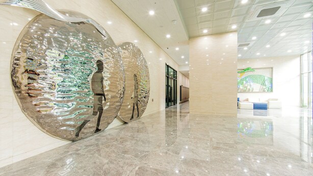 A spacious lobby with a polished marble floor, large reflective wall art, and a seating area with a blue accent. - Ariari Hotel (Jeongseon)