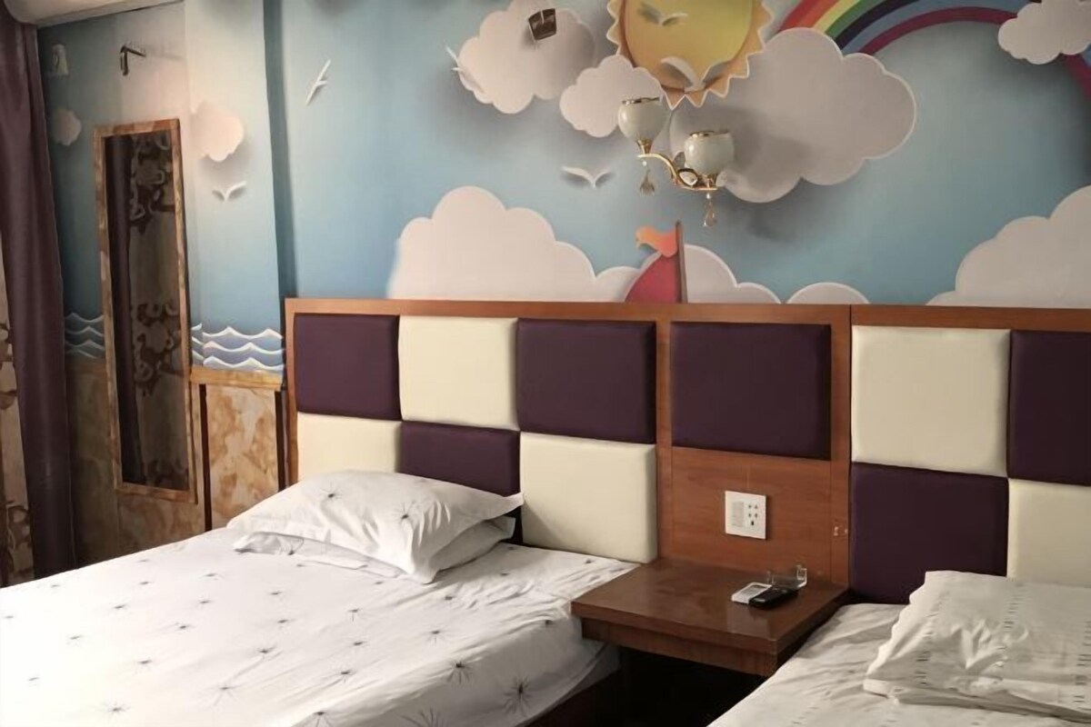 Een slaapkamer met een bed, nachtkastje en een muurschildering.