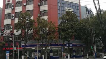 A multi-story building with commercial establishments on the ground floor, including a pharmacy and a convenience store.