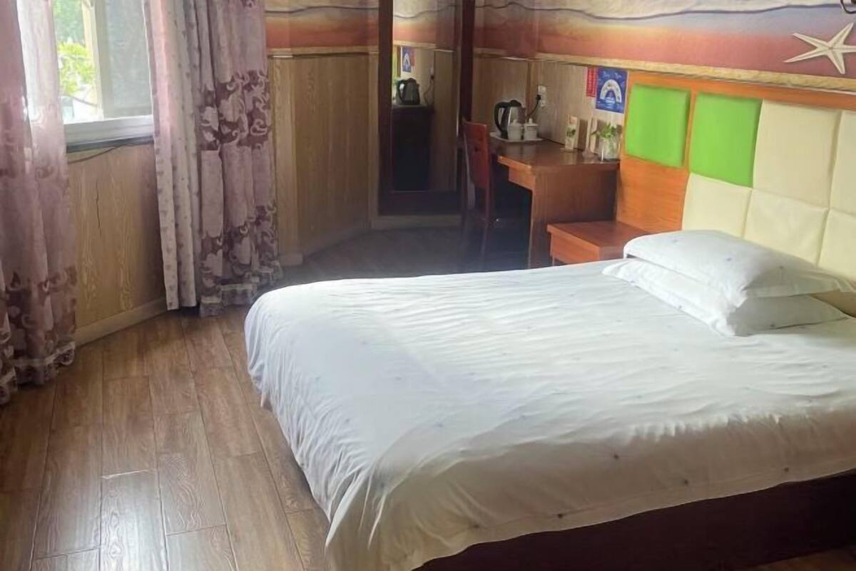 A hotel room with a bed, a desk, and a chair.