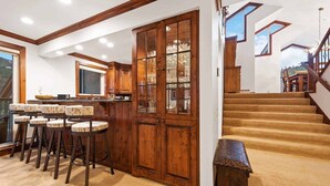 A spacious kitchen with wooden cabinetry and a bar area with stools. - 2 Bedroom Residence in the Heart of Beaver Creek Village - Ski In, Ski Out (Avon)