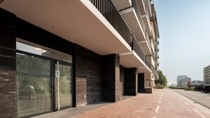 Un edificio moderno con un sendero adoquinado de ladrillo, ventanas amplias y techo plano.