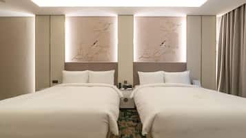 A hotel room with two beds, a large mirror, and a decorative wall piece.