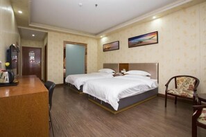 Ein Hotelzimmer mit zwei Betten, einem Schreibtisch und einem Stuhl.