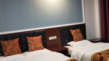 A hotel room with two beds, a large window, and a dark headboard.
