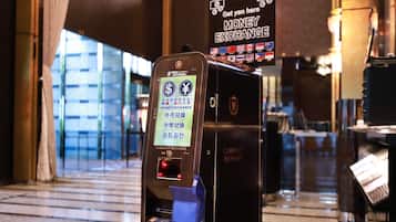 A currency exchange machine with multiple currency options and a sign indicating a money exchange service.