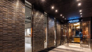 The exterior of APA Hotel with a modern design, featuring a glass entrance and a sign above the door. - APA Hotel Tokyo Nishikasai Ekimae (Tokyo)
