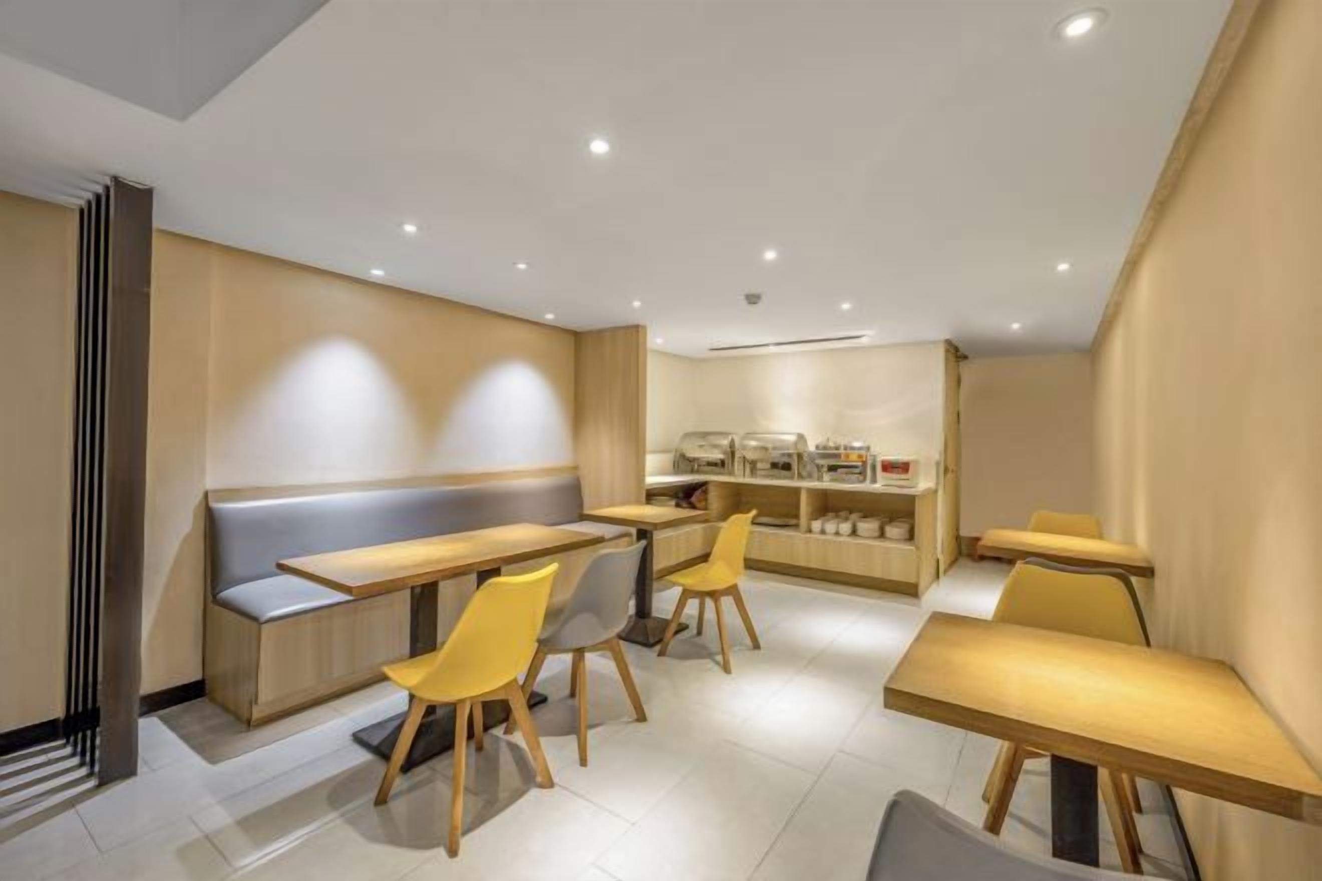A modern dining area with tables and chairs, a counter, and a seating bench.