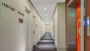 A hotel corridor with directional signs, an elevator, and a patterned carpet. - Rest Motel Hotel Taizhou Luqiao 2nd (Taizhou)