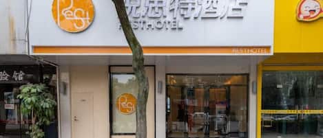 Un hotel con un letrero que dice 'Resthotel' y un logotipo con una 'R' y una 'H' estilizadas.