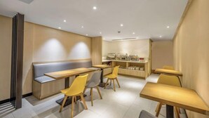 A modern cafe with wooden tables and chairs, a counter with a display case, and a bench area. - Rest Motel Hotel Taizhou Luqiao 2nd (Taizhou)